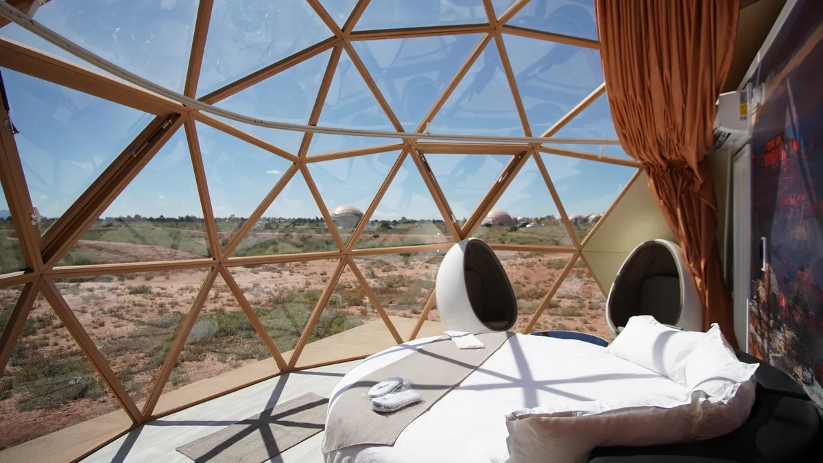 Hanging chairs inside a geodesic dome overlooking the landscape