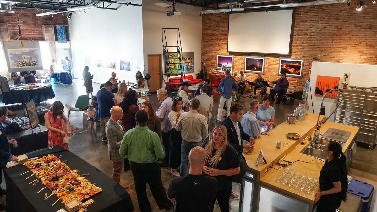 An elevated view of guests, refreshments, and musicians at the Texas environmental community event
